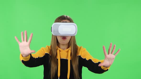 Portrait of Modern Girl in Yellow Hoodie with Virtual Reality Headset or 3D Glasses