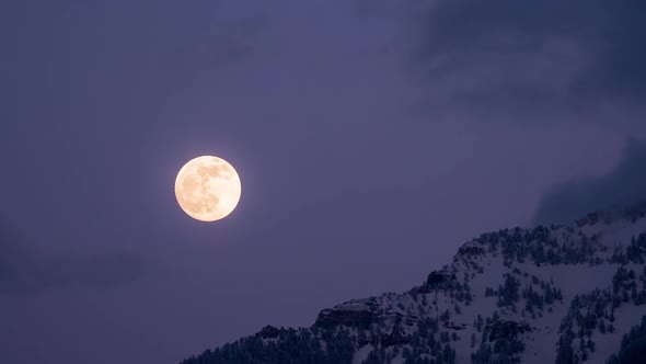 Full moon rising over mountain in time lapse