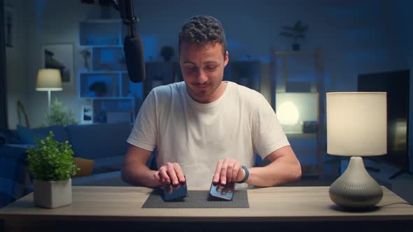 Young Handsome Man Makes an Overview of Two Smartphones