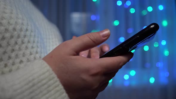 Woman Checks Social Media with Phone in Winter Evening