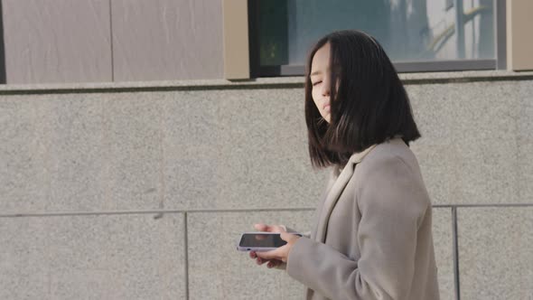 Side View of an Adult Asian Businesswoman Walking in the City