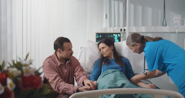 Husband Visiting Wife in Hospital and Talking To Doctor