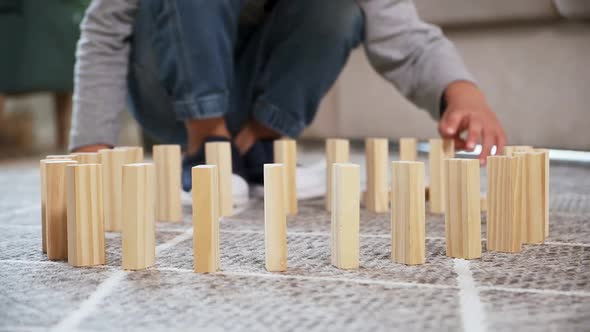 Child Builds a Row of Wooden Block in a Circle for a Domino Effect