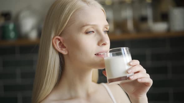 Healthy Woman Drinking Milk From Glass on Kitchen