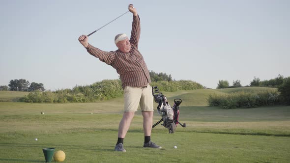 Portrait Mature Man Warming Up Before the Game, Holding a Golf Club Over His Head