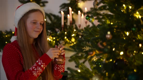 Pretty Girl Decorating Fir Tree on Christmas Eve