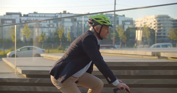 Hipster Businessman Commuter with Electric Bicycle Traveling Home From Work in City