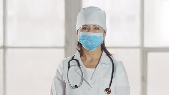 Portrait of a smiling lady doctor wearing a mask, looking at camera.professional female doctor weari