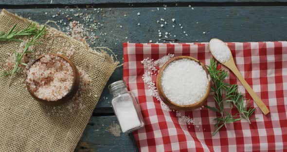 Video of rosemary twig and spoon of salt on wooden background