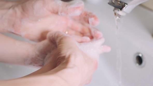 Mother with Little Son Washing Hands Together