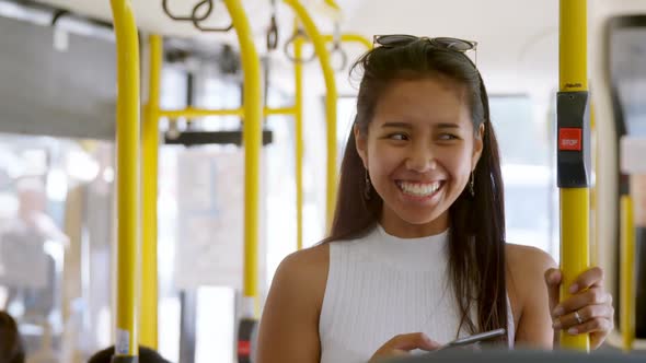 Teenage girl with mobile phone standing in the bus 4k