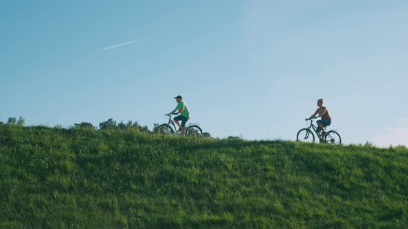 Mom and Teenage Son Riding Bicycles in a Field