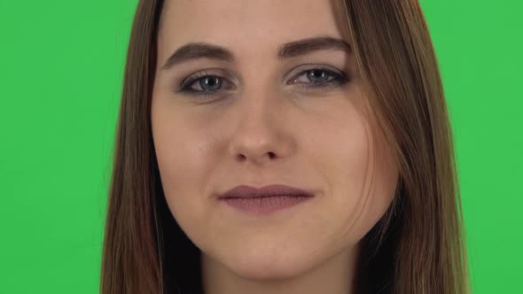 Woman Looking Straight, Smiling and Raises an Eyebrow Flirting. Close Up. Green Screen