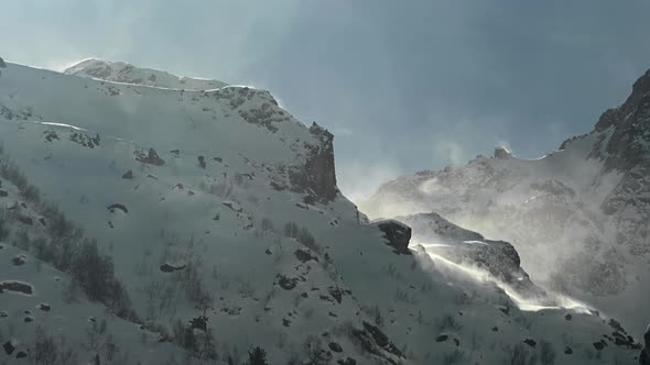 Timelapse on a Telephoto Lens of Snowcapped Peaks of High Mountains with Snow Blowing From the Peaks