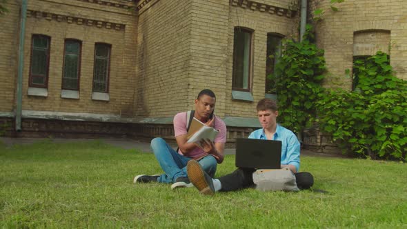 Diverse Male and Female Couples Studying Using Gadgets Books Outdoors