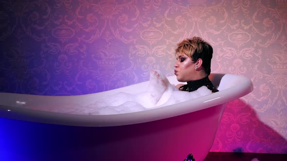 Transsexual take bath in neon light. Woman. Cosmetic foam bisexual trans. People