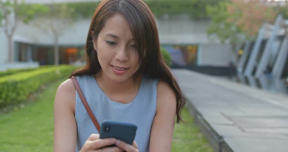 Woman look at the cellphone in the park