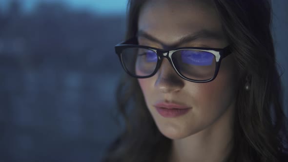 Reflection of the Monitor with Glasses. Attractive Young Girl Working on a Laptop