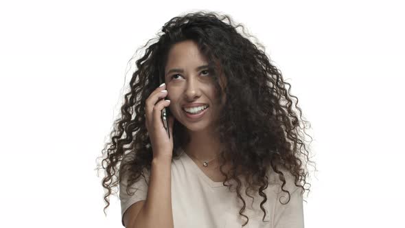 Closeup of Attractive Woman with Curly Long Hairstyle Picking Up the Phone Looking Surprised and