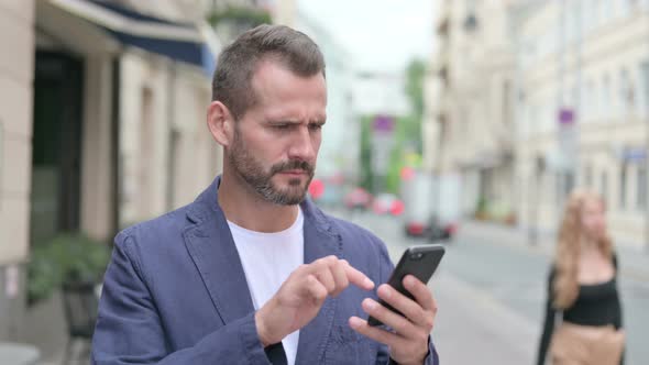 Mature Adult Man Having Loss on Smartphone