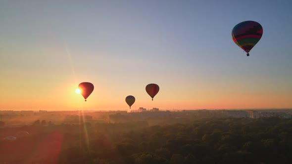 Aerial Drone View Silhouette of Colorful Hot Air Balloon Flying Over Green Park in Small European