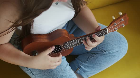 Hands of Female Guitarist Play Ukulele Closeup