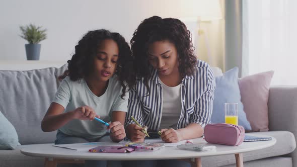 Cheerful African American Mother and Daughter Drawing Pictures at Home Spending Happy Weekend Time