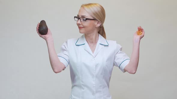 Nutritionist Doctor Holding Organic Avocado Fruit and Medicine or Vitamin or Omega 3 Capsules