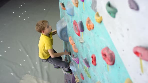 Caucasian Teenager Climbing Wall at Gym
