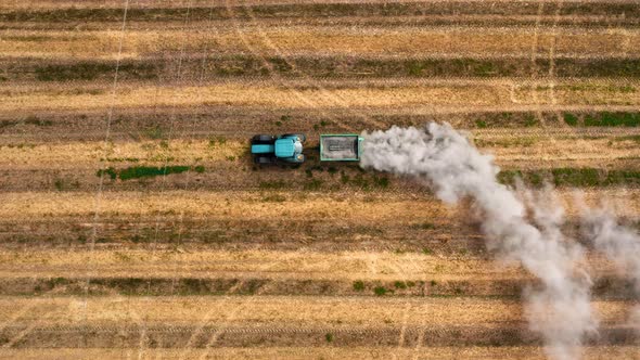 Top view of tractor plowing field in autumn, aerial view