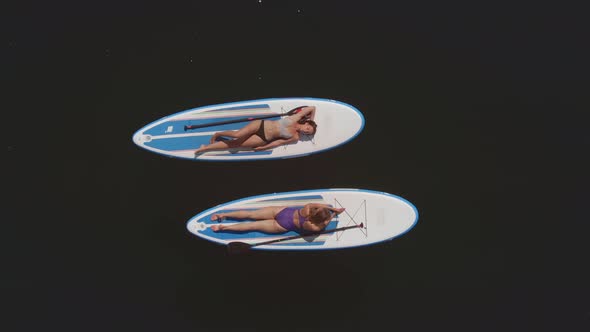 Two Women Alone on Paddleboards in Lake