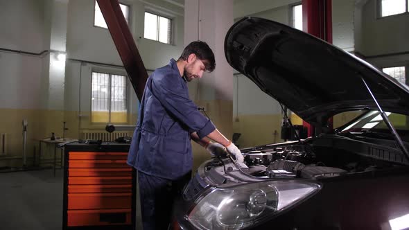 Auto Mechanic Checking Oil Level in Car Engine