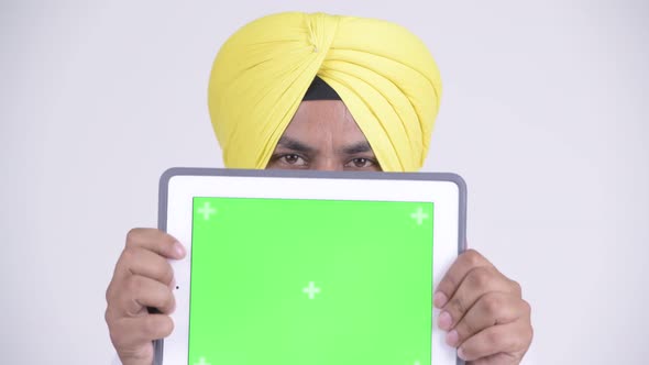 Happy Bearded Indian Sikh Businessman Covering Face with Digital Tablet
