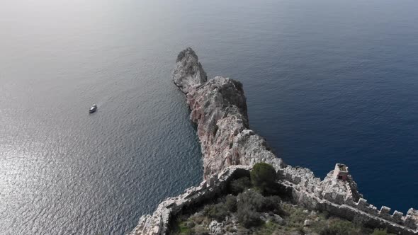 Remains of fortress on cliff of rocky mountains in sea