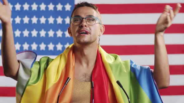 Gay Man Wrapped in Rainbow Flag Giving Speech during Press Conference