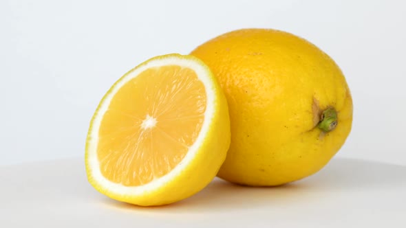 Whole and Half Lemon Rotating on White Background