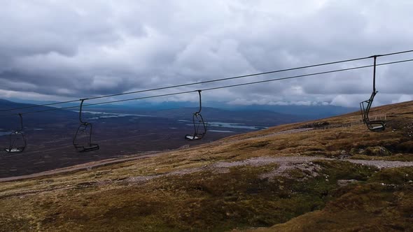 Cinematic panning drone shot of scottish highland mountain lift