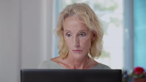 Close Up of Concentrated Mature Woman Working on Laptop