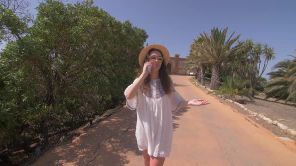 Beautiful smiling woman walking near old luxury villa in Italy