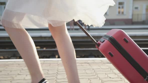 View of Girl's Stepping with Suitcase on Platform with Smile on Face