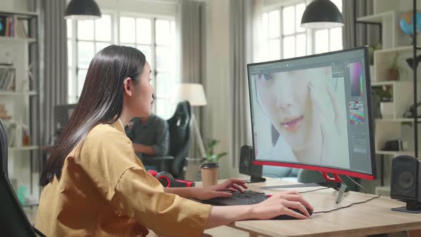 Asian Female Digital Editor Works In Photo Editing Software On Her Personal Computer In Office