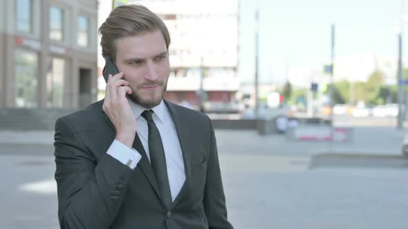 Angry Businessman Talking on Phone Outdoor