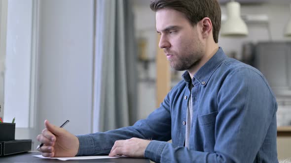 Beard Young Man Writing Documents in Office