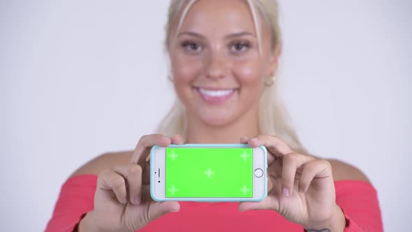 Face of Happy Young Beautiful Blonde Woman Showing Phone