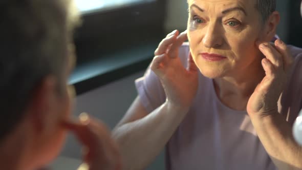 Attractive Senior Woman Looking at Herself in Mirror