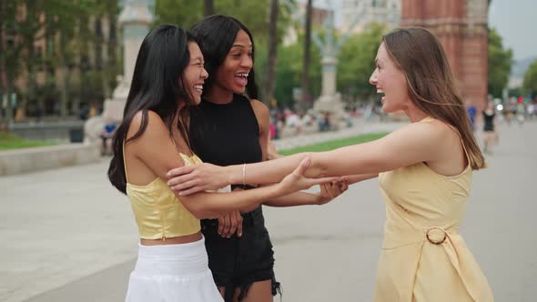 Overjoyed Multiethnic Girlfriends Hugging and Feeling Happy to See Each Other Outdoors