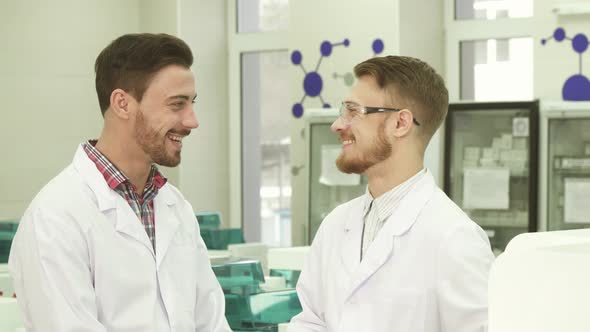 Two Laboratory Technicians Communicate on Working Subjects