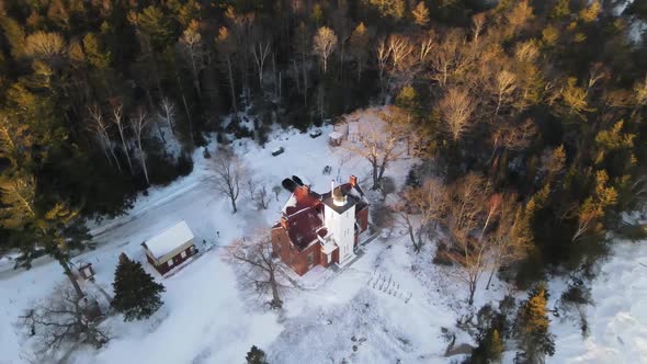 4k drone video of 40 Mile Point Lighthouse in Presque Isle County in Michigan during the winter.