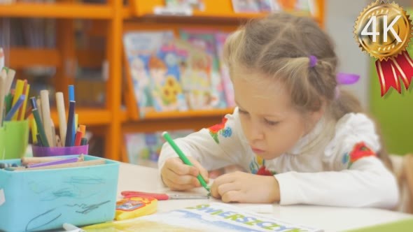 Concentrated Little Blonde Girl is Painting By