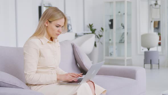 Smiling girl typing message to friends at home